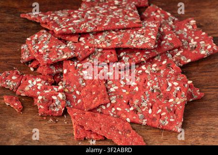 Rote-Bete-Kracker-Stücke, zerbröseltes dünnes Brot aus Rote-Bete-Ruske, zerbrochenes rotes Diät-Vollkornknäckebrötchen, verschiedene Samen-Vollkornknäckebrot, langes Knäckebrot Stockfoto