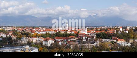 Klarer Blick auf Kranj, Slowenien mit mittelalterlicher Altstadt, Kirchtürmen und Alpenlandschaft unter blauem Himmel Stockfoto