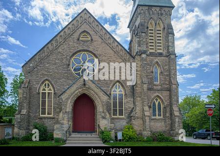 Historische First Baptist Church mit Rosettenfenster, steinernem Glockenturm und rotem gewölbtem Eingangstor. Stockfoto