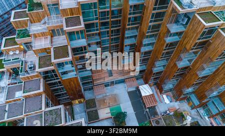 Luftaufnahme eines modernen Apartmentgebäudes aus Holz mit grünen Dächern, Holzbalkonen und Glasfassaden in Schweden. Stockfoto