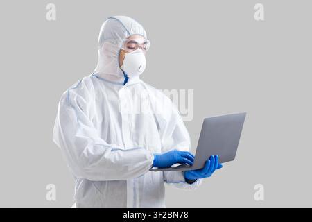 Der asiatische männliche Wissenschaftler im Schutzanzug schreibt Informationen Stockfoto
