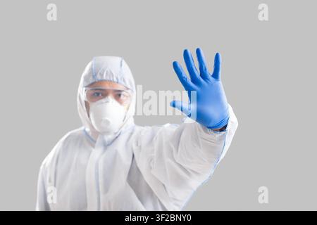 Mann im Schutzanzug macht Stoppschild mit Hand Stockfoto