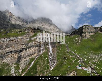 Luftbild des Gebiets um den Chitta-Katha-See mit kaskadierenden Wasserfällen, die an schroffen Bergklippen hinabfließen, mit üppig grünen Hängen und kleinen Zelten in Kel Stockfoto