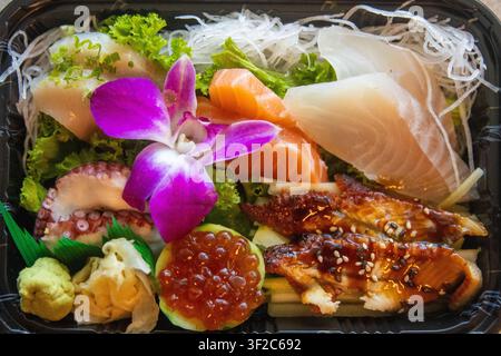 Eine Draufsicht auf eine Premium-Japanische Sashimi-Auswahl mit frischem Lachs, Weißfisch, Unagi-Aal, Tintenfisch und Ikura-Lachseier, garniert mit Stockfoto