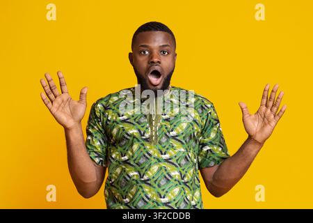 Schockiert afrikaner Kerl mit offenen Mund hält Hände weit offen Stockfoto