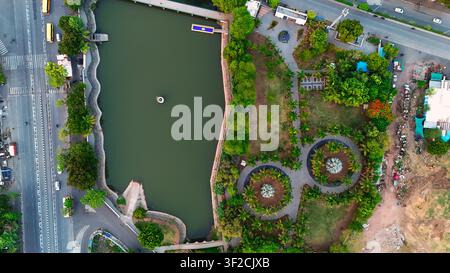 Top-Down-Drohnenblick auf einen Stadtpark mit kreisförmigem Gartendesign und See Stockfoto