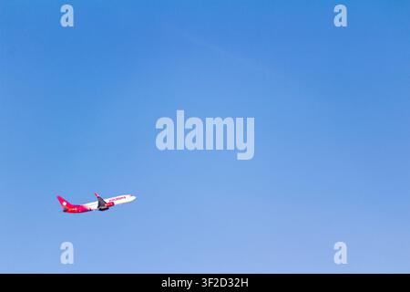 Sankt Petersburg, Russland – 18. Februar 2026: Izhavia-Passagierflugzeug in roter und weißer Lackierung, das in den blauen bewölkten Himmel abhebt. Verkehrsflugzeug Stockfoto