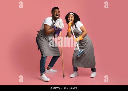 Inlandsband. Glückliches Afroamerikanisches Paar, Das Beim Putzen Der Wohnung Zusammen Täuscht Stockfoto