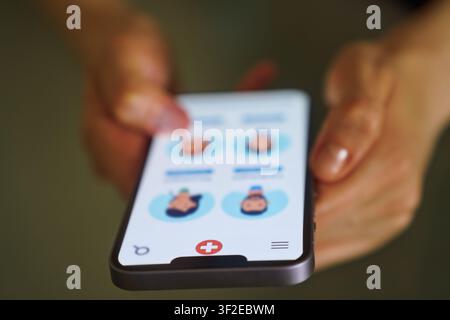 Nahaufnahme von Händen, die ein Smartphone halten, das eine Gesundheits-App-Oberfläche anzeigt. Der Bildschirm zeigt Optionen für virtuelle Beratungen, die die Integrati Stockfoto
