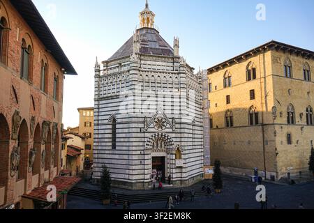 Ansicht des Baptisteriums von San Giovanni in Corte mit seinen charakteristischen weißen und grünen Marmorstreifen, gelegen auf einem historischen Platz in Pistoia, Toskana Stockfoto