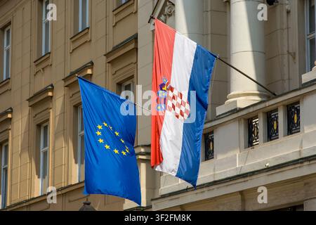 Kroatien - Zagreb - Die nationale kroatische Staatsflagge zusammen mit der Flagge der Europäischen Union, die an der Wand des Regierungsgebäudes in der Hauptstadt hängt Stockfoto