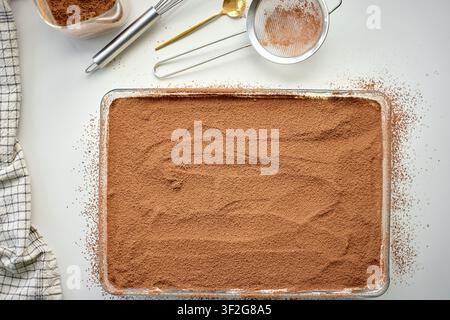 Tiramisu-Dessert ist mit Kakaopulver in einer Glasschale bedeckt. Konzept für hausgemachtes Dessert, Rezept und italienisches Essen Stockfoto