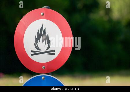 Nahaufnahme eines runden Verbotszeichens, das Lagerfeuer und offene Flammen verbietet, an einem Pfahl im Freien montiert. Sicherheitswarnsignal Stockfoto