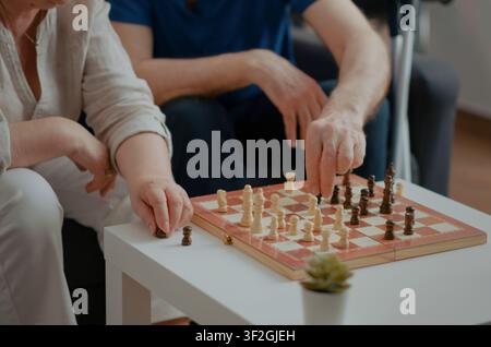 Seniorenpaar genießt gemeinsam ein Schachspiel, während ein Seniorenpaar einen Schachbrettwettbewerb im Ruhestand genießt, der Checkmate-Strategie, Freizeit und kluge Aktivität kombiniert. Stockfoto