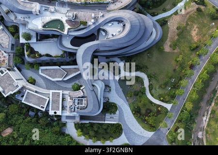 Ein faszinierender Blick von oben offenbart einen dramatischen zeitgenössischen Gebäudekomplex in Zhangzhou, Fujian, mit geschwungenen, terrassierten Gehwegen Stockfoto