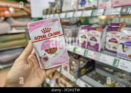Royal Canin Katzenfutter für Kätzchen, rosa Verpackung, wird im Supermarkt von Hand gehalten, Nassfutter, Katzenfutter Kaufprodukt, Futterschüssel, Tierhandlung, Omnichannel p Stockfoto