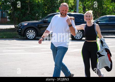 Kiew, Ukraine – 17. Juli 2026: Ein lächelndes Paar geht gemeinsam in der Nähe des Eingangs zum VDNH (Expocenter) an einem sonnigen Sommertag und genießt die Freizeit im Freien Stockfoto