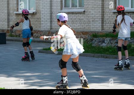 Kiew, Ukraine - 17. Juli 2026: Kinder, die Helme und Schutzausrüstung tragen, üben gemeinsam Inlineskaten in einem Freiluft-Erholungsgebiet am WDNH (Ex Stockfoto
