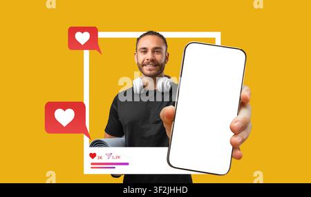 Junger Mann hält Smartphone mit leerem Bildschirm und Yogamatte zu Hause, Fitnesskonzept Stockfoto