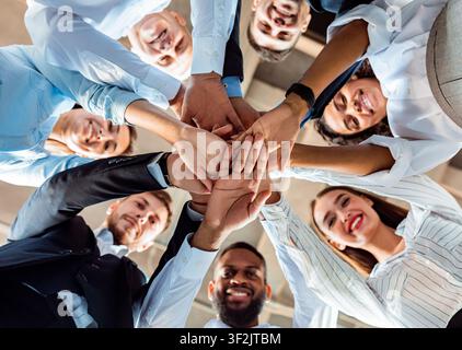 Mitarbeiter, Die Während Der Besprechung Im Büro In Den Händen Der Circle Holding Stehen Stockfoto