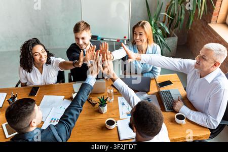 Glückliche Mitarbeiter, Die High-Five Feiern, Um Im Büro Den Erfolg Des Unternehmens Zu Feiern Stockfoto