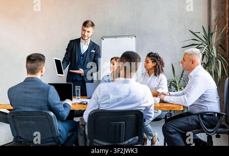Geschäftsmann Zeigt Tablet-Präsentation Projekt Für Kollegen In Modern Office Stockfoto