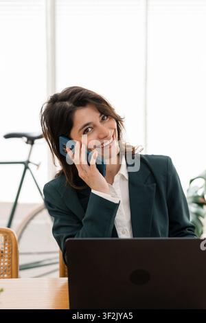 Junge Frau telefoniert und arbeitet remote Stockfoto