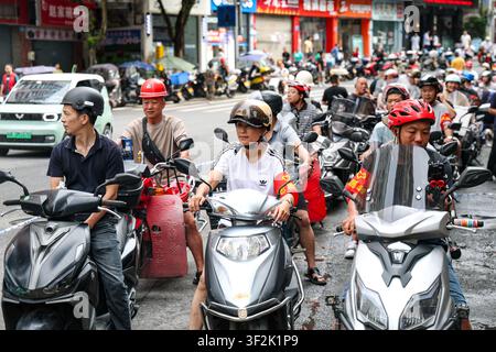 (260719) -- CHONGQING, 19. Juli 2026 (Xinhua) -- Motorradfreiwillige warten in einer Schlange an einem Sammelpunkt, um Nachschub und Personal in den autonomen Bezirk Pengshui Miao und Tujia von Chongqing, Südwestchina, am 19. Juli 2026 zu liefern. Um 9:08 Uhr am Freitag kam es im Unterbezirk Hanjia von Pengshui zu einem durch Regenfall ausgelösten Bergrutsch, der mehr als 10 Wohnhäuser verschüttete, während einige Anwohner eingeschlossen und vermisst wurden. China aktivierte eine nationale Notfallreaktion der Stufe II für geologische Katastrophen. Mehrere Rettungstruppen, einschließlich Notfallreaktion, Brandbekämpfung und Stockfoto