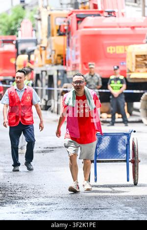 (260719) -- CHONGQING, 19. Juli 2026 (Xinhua) -- Freiwillige arbeiten am Ort eines Bergsturzes im autonomen Bezirk Pengshui Miao und Tujia von Chongqing, Südwestchina, am 19. Juli 2026. Ein regeninduzierter Bergsturz ereignete sich am Freitag um 9:08 Uhr im Unterbezirk Hanjia von Pengshui, wobei mehr als 10 Wohnhäuser begraben wurden, während einige Anwohner eingeschlossen und vermisst wurden. China aktivierte eine nationale Notfallreaktion der Stufe II für geologische Katastrophen. Mehrere Rettungstrupps, darunter Notfallevakuierung, Brandbekämpfung und öffentliche Sicherheit, eilten zum Ort des Geschehens und Stockfoto