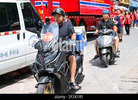 (260719) -- CHONGQING, 19. Juli 2026 (Xinhua) -- Motorradfreiwillige transportieren Nachschub in der Nähe der Rettungsstelle eines Bergsturzes im autonomen Kreis Pengshui Miao und Tujia von Chongqing, Südwestchina, am 19. Juli 2026. Ein regenbedingter Bergsturz ereignete sich am Freitag um 9:08 Uhr im Unterbezirk Hanjia von Pengshui, wobei mehr als 10 Wohnhäuser begraben wurden, während einige Anwohner eingeschlossen und vermisst wurden. China aktivierte eine nationale Notfallreaktion der Stufe II für geologische Katastrophen. Mehrere Rettungstrupps, darunter Notfallmaßnahmen, Brandbekämpfung und öffentli Stockfoto
