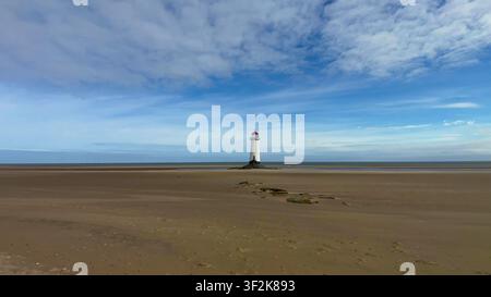 TALACRE, WALES - 15. AUGUST 2025: Der historische Leuchtturm Point of Ayr steht auf der sandigen Weite von Talacre Beach in Nordwales unter einem blauen Himmel. Stockfoto