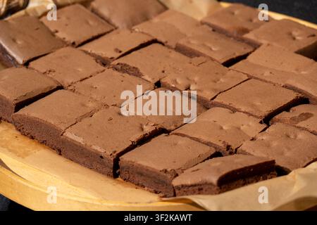 Brownie-Stapel auf Papier. Schokoladenkuchen-Stack, selbstgemachtes quadratisches Dessert mit Fudge, viele dunkle Kakaokeks auf dem Straßenfoodmarkt Stockfoto