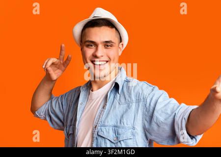 Positiver Reisender, der Frieden zeigt und Selfie macht Stockfoto