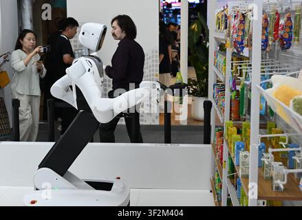 Shanghai, China. 19. Juli 2026. Ein Roboter holt ein Getränk aus dem Regal während der Welt-AI-Konferenz 2026 in Shanghai, Ostchina, am 19. Juli 2026. Die laufende Welt-AI-Konferenz 2026 entpuppt sich als ein hochkompetitiver Wettbewerb für allgemeine verkörperte KI-Produkte von mehr als 200 Anbietern. Es handelt sich um ein allgemeines Intelligenzsystem, das es Robotern ermöglicht, variable Aufgaben auszuführen und sich an unterschiedliche Anwendungsszenarien anzupassen. Credit: Huang Xiaoyong/Xinhua/Alamy Live News Stockfoto