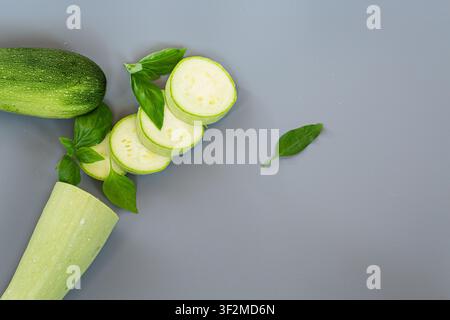 Gesunde biologische Zucchinianordnung auf minimalistischem grauem Hintergrund . Stockfoto