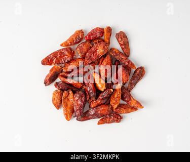 Trockene Chilischoten isoliert, rote Chili-Gewürzansicht von oben. Ganzer pikanter Paprikahaufen, kleines rotes Chili-Gewürz auf weißem Hintergrund, scharfe Cayennepfefferflocken Stockfoto