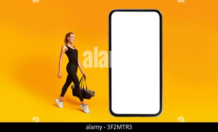 Junge Frau trägt Yogamatten und Tasche und geht selbstbewusst, Fitness-Konzept Stockfoto