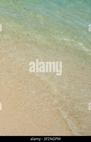 Kristallklares flaches türkisfarbenes Wasser über sandigem tropischem Strand, ruhige Sommerlandschaft am Meer. Stockfoto