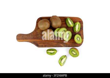 Kiwis auf Holzschneidebrett isoliert. Grün geschnittenes Kiwifrucht, pelzige Kivi-Scheiben, frische saftige tropische Früchte mit Samen, Kiwi auf weißem Hintergrund Stockfoto