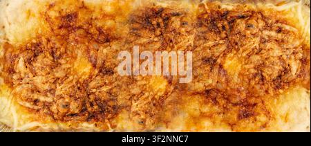 Lasagne-Strukturbildhintergrund, Nahaufnahme und Oberansicht. Ofen gebackenes Lasagne-Muster, gebackene knusprige Käsekruste Tapetenmuster Stockfoto