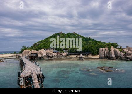 Holzsteg und Gehweg an der felsigen Küste der Insel Koh Nang Yuan mit türkisfarbenem Wasser, Thailand Stockfoto