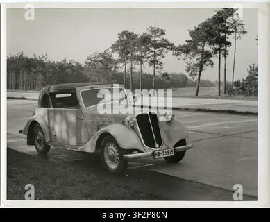 Vintage-Auto, Coupé, Werbefoto. Reichs-Autobahn, Ein Vintage-Auto parkt am Straßenrand mit Blick auf einen bewaldeten Horizont und die offene Straße, Kar Stockfoto