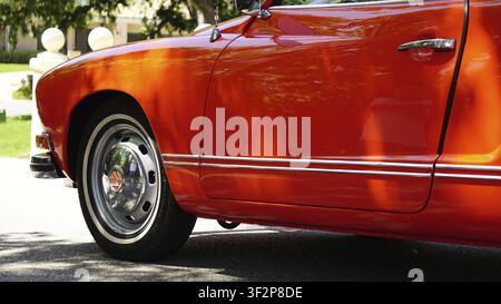 Seitenansicht eines vintage roten Autos mit Chromdetails und Rädern, von Sonnenlicht beleuchtet, 1973 Volkswagen Karmen Ghia Stockfoto