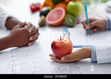 Nahaufnahme des weiblichen Arztes mit großem frischen roten apfel Stockfoto