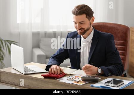 Ein Buchhalter, der im Amt Berechnungen macht Stockfoto