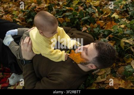 Fröhliches Baby spielt draußen im Herbst Stockfoto