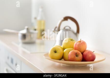 Obst auf dem Tisch, Wasserkocher auf dem Herd in der modernen Küche, Frühstück am Morgen, gesunde Lebensmittel und Vitamine Stockfoto