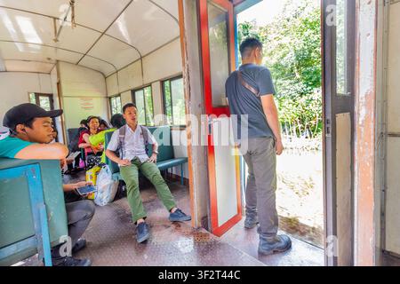 Passagiere sitzen in einem Zugabteil der Sabah State Railway in Beaufort, Malaysia, auf einer lokalen ländlichen Zugfahrt Stockfoto