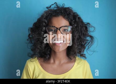Fröhliche schwarze Frau mit Brille lächelt strahlend Stockfoto