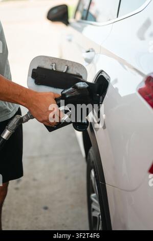 Mann tankt Benzin in einen weißen SUV Stockfoto